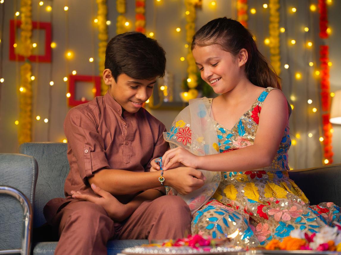 Raksha Bandhan 2026 पर भाई की कलाई पर राखी बांधती बहन